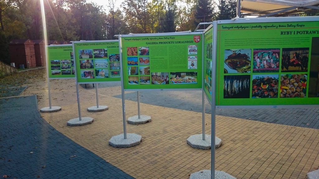 Wystawa plenerowa w Brzeźnicy, zielone plansze stoją na zewnątrz